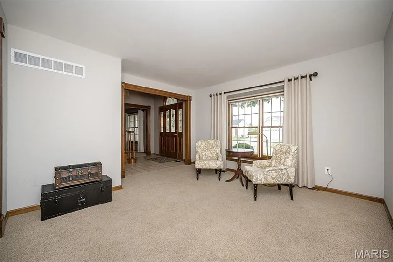 Neutral wall finishes, plush carpeting, wood-finish trim, and a window with curtains — 1551 Country Bend Drive, St Charles, MO 63303