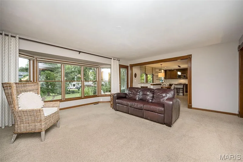 Expansive bay window, wood-trimmed archway, and neutral carpeting — 1551 Country Bend Drive, St Charles, MO 63303