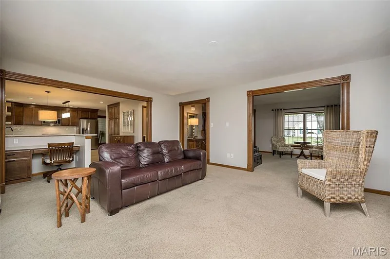 Living area with wood-framed doorways and neutral carpeting — 1551 Country Bend Drive, St Charles, MO 63303