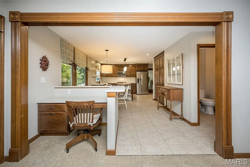 Built-in desk with wood-finish cabinetry, tile flooring, and wood trim detailing throughout — 1551 Country Bend Drive, St Charles, MO 63303