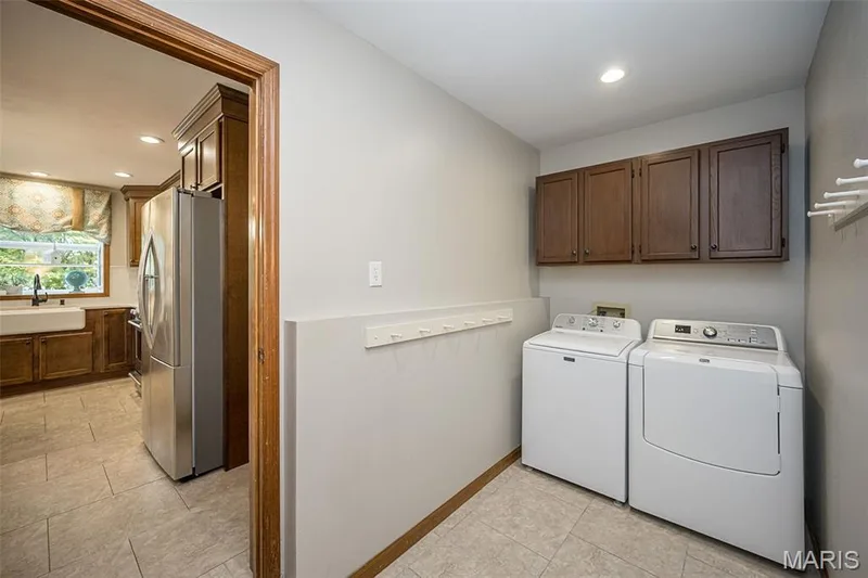 Laundry area featuring tile flooring, recessed lighting, and upper cabinetry — 1551 Country Bend Drive, St Charles, MO 63303