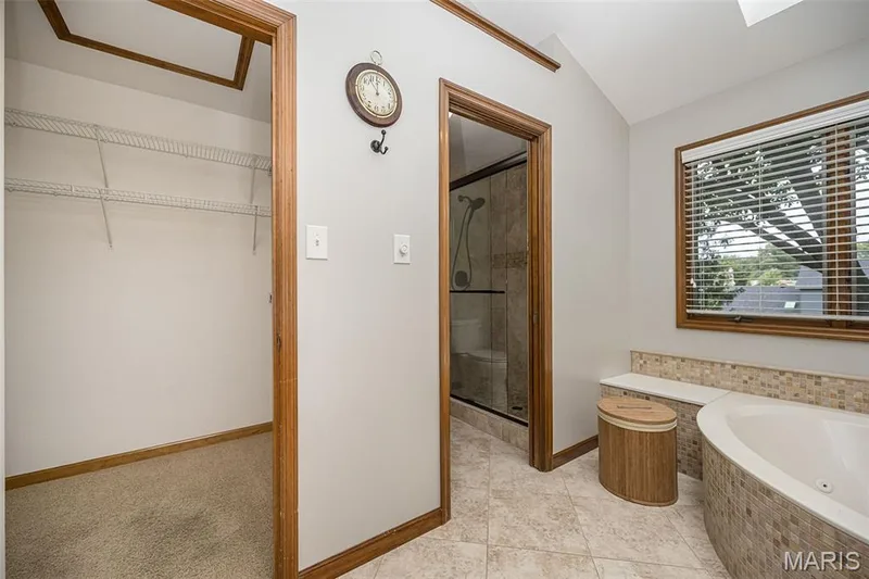 Tiled flooring, built-in soaking tub with mosaic tile surround, and a walk-in shower with glass enclosure — 1551 Country Bend Drive, St Charles, MO 63303