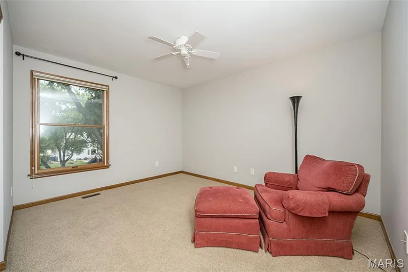 Ceiling fan with light kit, neutral tone carpeting, and wood-trim window — 1551 Country Bend Drive, St Charles, MO 63303