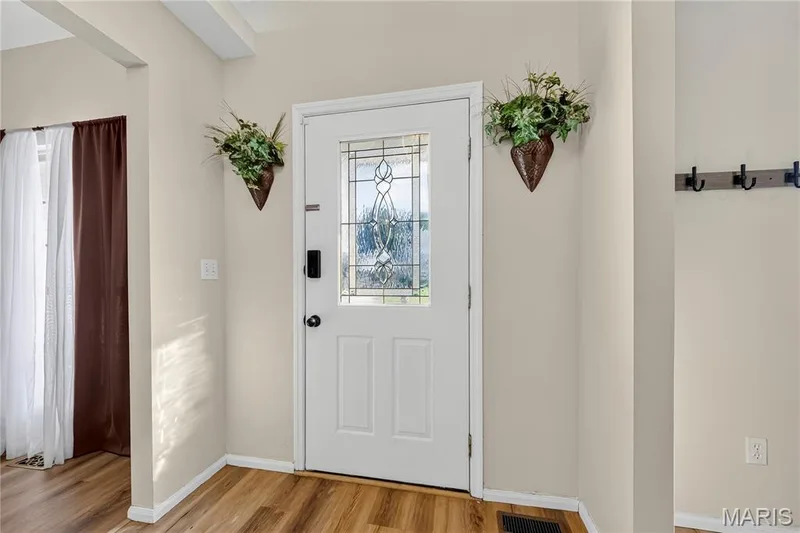 Entryway featuring wood-finish flooring and a white door with decorative glass inserts — 934 Annabrook Park Drive, O'Fallon, MO 63366