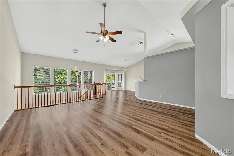 Vaulted ceilings, wood-finish flooring, a ceiling fan, and multiple windows with exterior views — 934 Annabrook Park Drive, O'Fallon, MO 63366