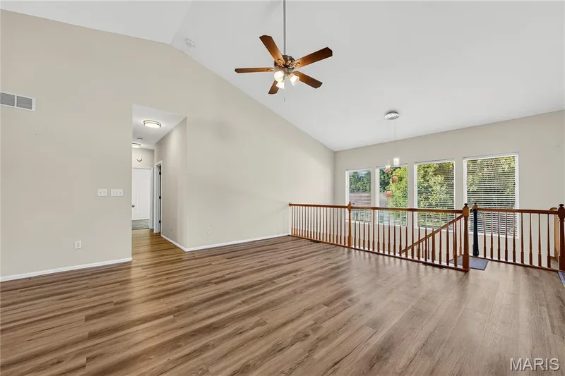 Vaulted ceiling, wood-finish flooring, ceiling fan, multiple windows, and wood banister — 934 Annabrook Park Drive, O'Fallon, MO 63366