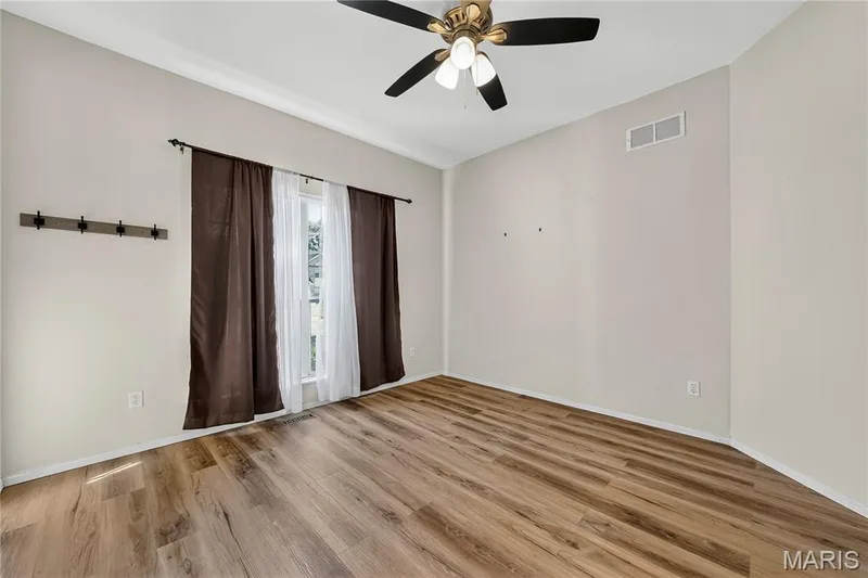 Wood-finish flooring with a ceiling fan light fixture and window — 934 Annabrook Park Drive, O'Fallon, MO 63366