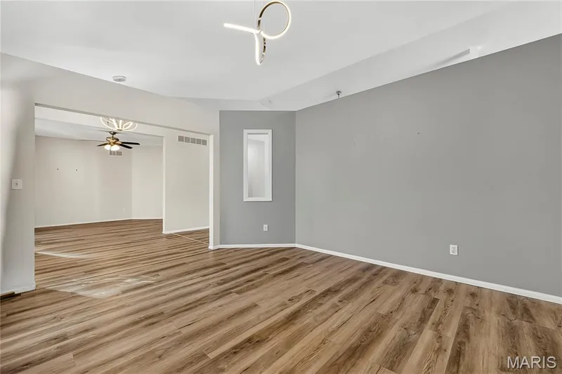 Wood-finish flooring throughout, modern ceiling light fixture, recessed lighting, and a neutral color palette — 934 Annabrook Park Drive, O'Fallon, MO 63366