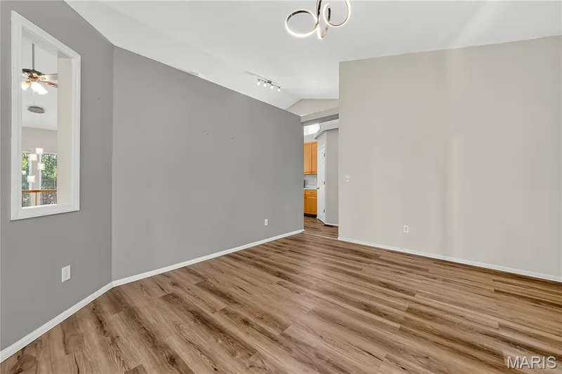 Vaulted ceiling with a contemporary light fixture, wood-finish flooring, and a decorative interior window — 934 Annabrook Park Drive, O'Fallon, MO 63366