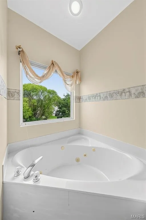 Corner jetted soaking tub with chrome fixtures, a window, and recessed ceiling lighting — 934 Annabrook Park Drive, O'Fallon, MO 63366