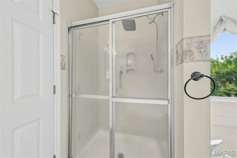 Shower enclosure with sliding glass doors, a rain shower head, and an additional handheld shower fixture — 934 Annabrook Park Drive, O'Fallon, MO 63366