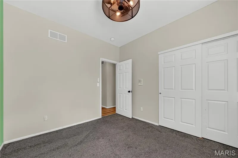 Plush carpeting, neutral wall color, white trim, white paneled doors, and a decorative ceiling light fixture — 934 Annabrook Park Drive, O'Fallon, MO 63366