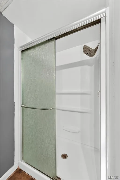 Shower stall with textured glass sliding doors, integrated shelving, and a bronze-finish shower head — 934 Annabrook Park Drive, O'Fallon, MO 63366