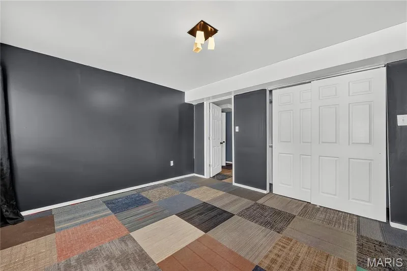 Multi-color square pattern flooring, white panel bi-fold doors, white interior door, and a flush mount ceiling light fixture — 934 Annabrook Park Drive, O'Fallon, MO 63366