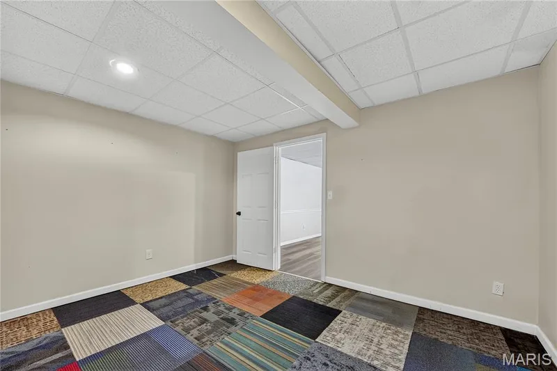 Recessed lighting in a drop ceiling, neutral wall paint, and patterned carpet tile flooring — 934 Annabrook Park Drive, O'Fallon, MO 63366