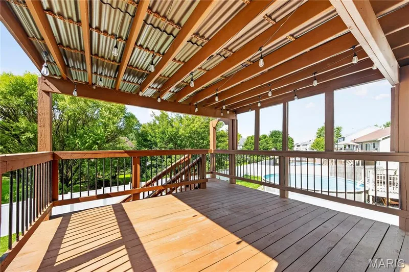 Covered deck with wood flooring, wood railings, and a corrugated metal ceiling — 934 Annabrook Park Drive, O'Fallon, MO 63366