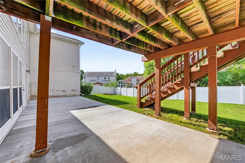 Ground-level concrete patio with an overhead wood deck structure — 934 Annabrook Park Drive, O'Fallon, MO 63366