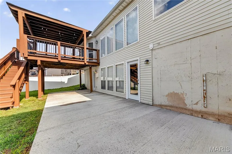 Covered wood deck with stairs, featuring a sloped roof — 934 Annabrook Park Drive, O'Fallon, MO 63366