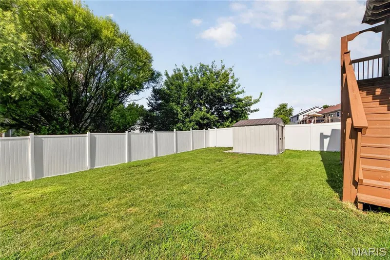 Expansive lawn featuring a privacy fence, storage shed, and a wood deck with stairs — 934 Annabrook Park Drive, O'Fallon, MO 63366