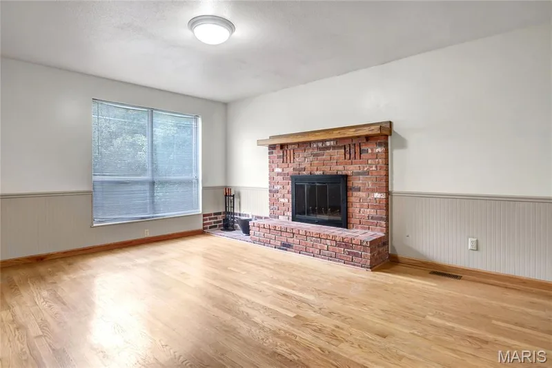 The family room has a wood burning fireplace and hardwood floors. — 1401 Tamarack Drive, St Charles, MO 63301