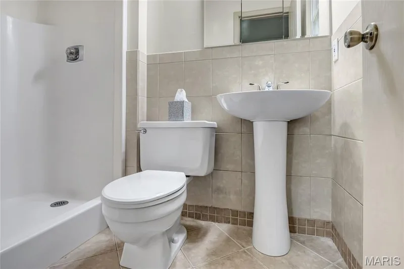 The primary bedroom features a pedestal sink and a walk-in shower. — 1401 Tamarack Drive, St Charles, MO 63301