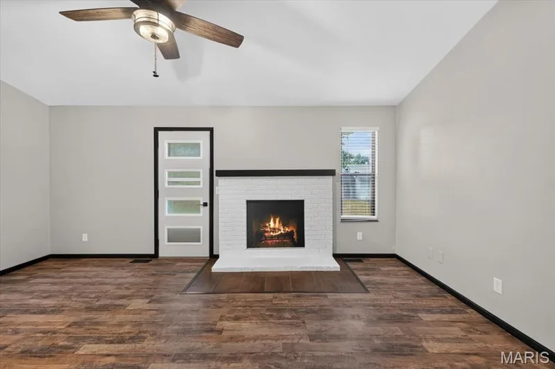 Updated LVP flooring travels throughout the home. The door to the left of the fireplace will deliver you into the back yard. — 1688 Knightwood Lane, O'Fallon, MO 63366