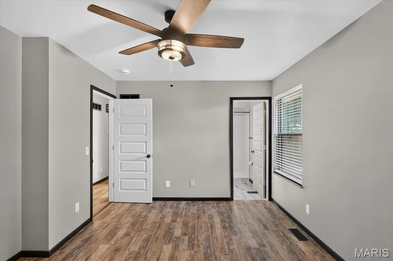 Most rooms in the house have these very cool ceiling fans. The doorway to the right takes you to the primary bath. — 1688 Knightwood Lane, O'Fallon, MO 63366