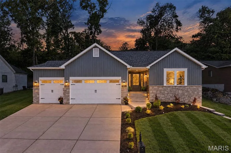 Beautiful landscape and architectural lighting create a warm welcome after sunset. — 11075 Village Drive, Foristell, MO 63348