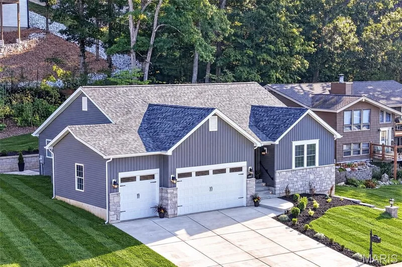 A generous driveway and spacious three-car garage provide abundant parking and storage. — 11075 Village Drive, Foristell, MO 63348