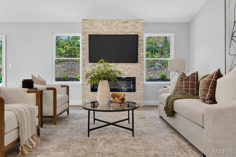 A floor-to-ceiling stone fireplace creates a striking focal point in the vaulted great room. — 11075 Village Drive, Foristell, MO 63348