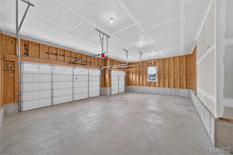 The spacious three-car garage features 8-foot doors and abundant parking and storage. — 11075 Village Drive, Foristell, MO 63348