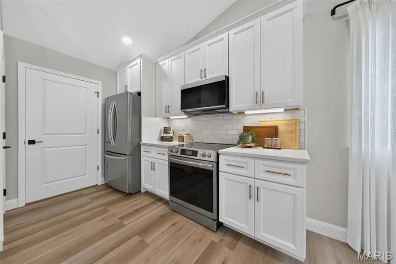 Crown-topped cabinetry, quartz countertops and stainless appliances complete the kitchen’s polished design. — 11075 Village Drive, Foristell, MO 63348