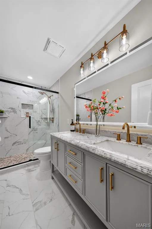 Dual vanity with stone countertop and gold-finish fixtures — 11075 Village Drive, Foristell, MO 63348