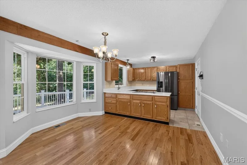 Hardwood flooring and a bay window define the dining area — 20 Ardennais Road, St Peters, MO 63376