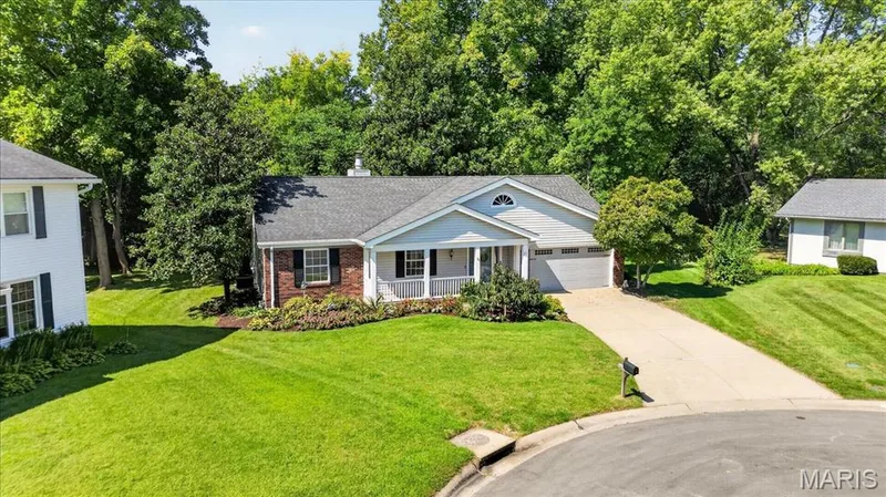 Traditional ranch-style home featuring a covered front porch, an attached two-car garage, and a brick and siding exterior — 20 Ardennais Road, St Peters, MO 63376
