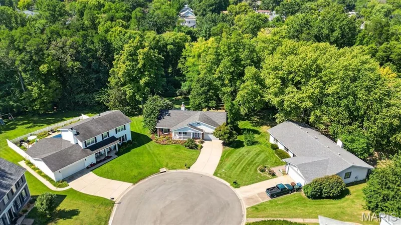 Private cul-de-sac setting with extensive green space, mature trees, and a concrete drive — 20 Ardennais Road, St Peters, MO 63376