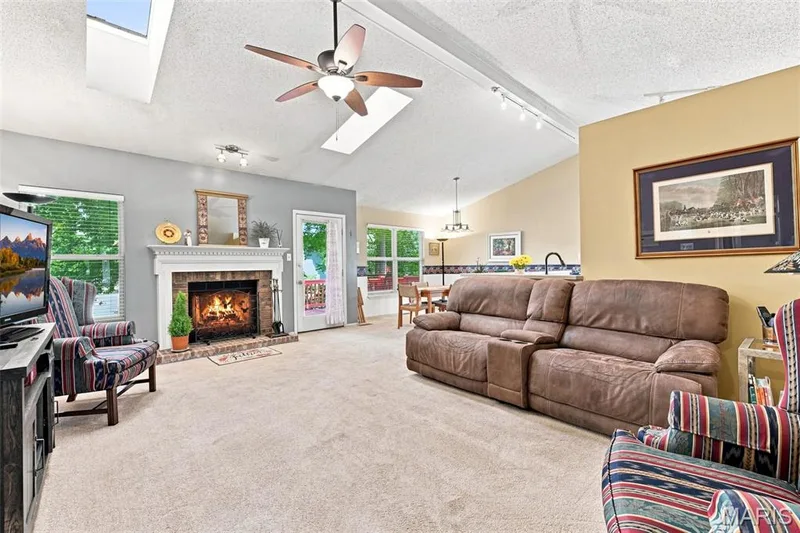Vaulted ceiling with skylights, ceiling fan, and track lighting — 55 Treeshade Court, St Peters, MO 63376