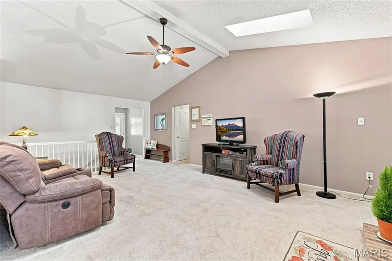 Vaulted ceiling with exposed beam, ceiling fan with light, and recessed lighting — 55 Treeshade Court, St Peters, MO 63376