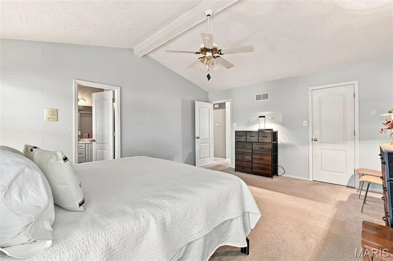Vaulted ceiling with exposed beam, ceiling fan, and light-colored walls — 55 Treeshade Court, St Peters, MO 63376