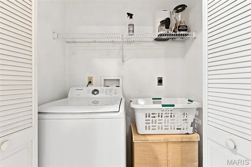 Laundry closet with louvered bi-fold doors, a built-in wire shelf, and an included top-load washing machine — 55 Treeshade Court, St Peters, MO 63376