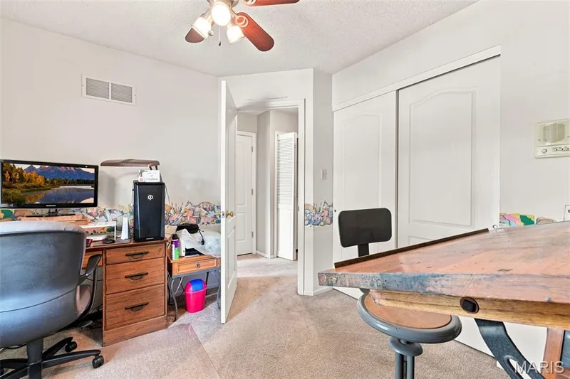 Ceiling fan with integrated lighting, carpet flooring, and white bi-fold closet doors — 55 Treeshade Court, St Peters, MO 63376