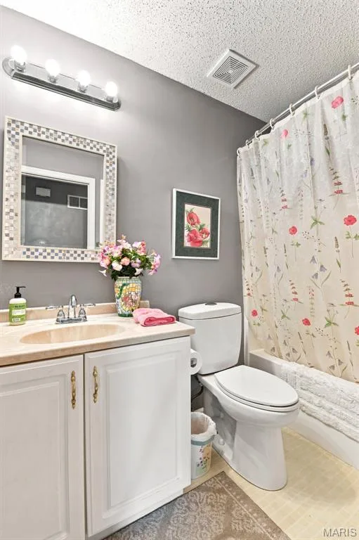 White vanity with gold-tone hardware, a beige countertop, and an integrated sink — 55 Treeshade Court, St Peters, MO 63376