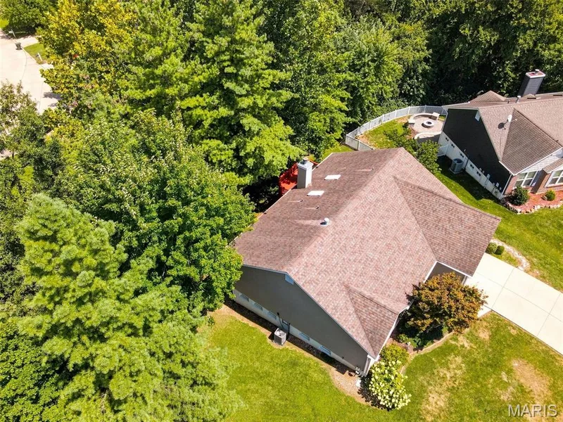Gable roofline with brown shingles, light gray siding, and a white chimney — 55 Treeshade Court, St Peters, MO 63376