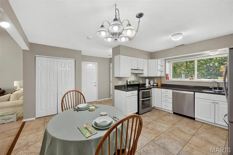 Kitchen featuring white cabinetry and dark countertops — 1 Rue De Paix #6, Lake St. Louis, MO 63367
