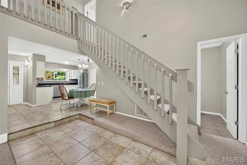 Open-concept layout featuring a kitchen, dining area, and staircase — 1 Rue De Paix #6, Lake St. Louis, MO 63367