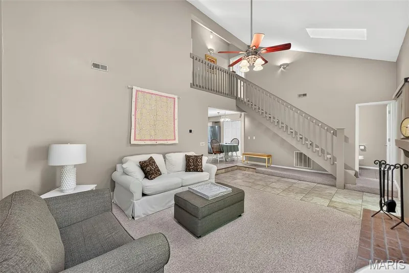 Vaulted ceiling with skylight, staircase with wood railing — 1 Rue De Paix #6, Lake St. Louis, MO 63367