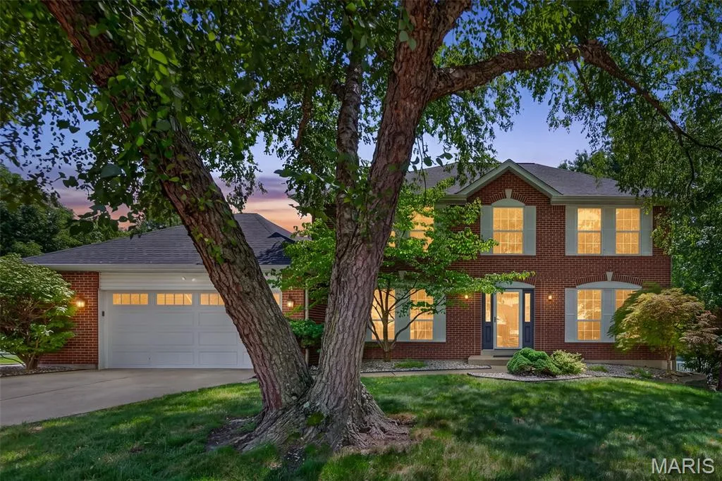 Brick exterior with light-colored window shutters, a two-car garage, and a dark front door — 10 Docs Ct., St Charles, MO 63303