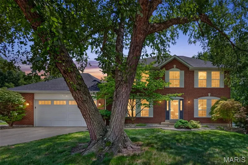Brick exterior with light-colored window shutters, a two-car garage, and a dark front door — 10 Docs Ct., St Charles, MO 63303