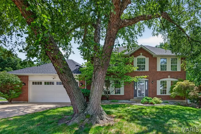 Brick exterior, white garage door, gabled roofline, front entry door, and manicured landscaping — 10 Docs Ct., St Charles, MO 63303