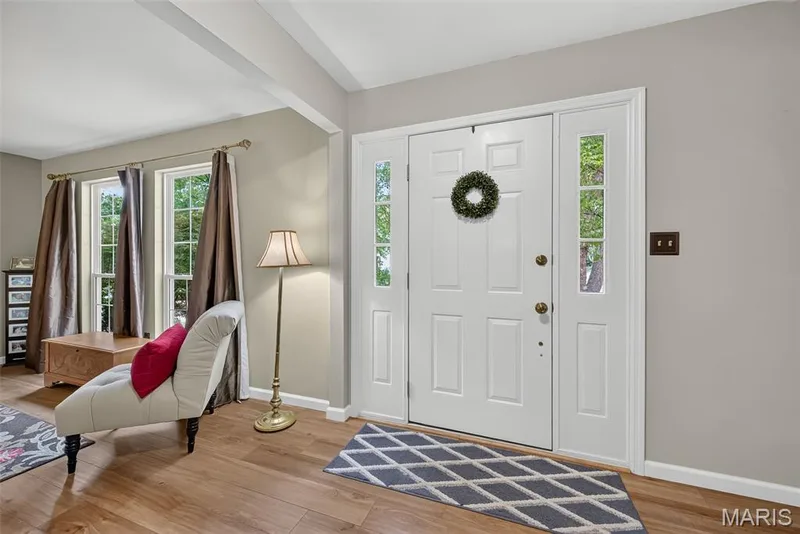 Entryway featuring a paneled door with glass sidelights, wood-finish flooring, and exposed ceiling beams — 10 Docs Ct., St Charles, MO 63303
